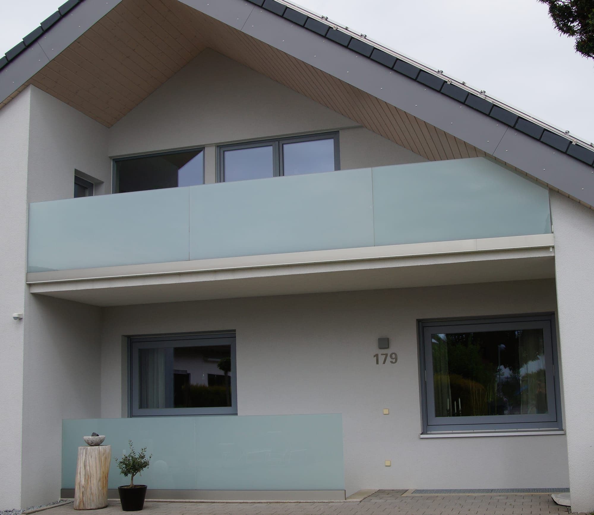 Balkon mit Glasbrüstung an einem modernen Wohnhaus, gefertigt von Maier Metallbau